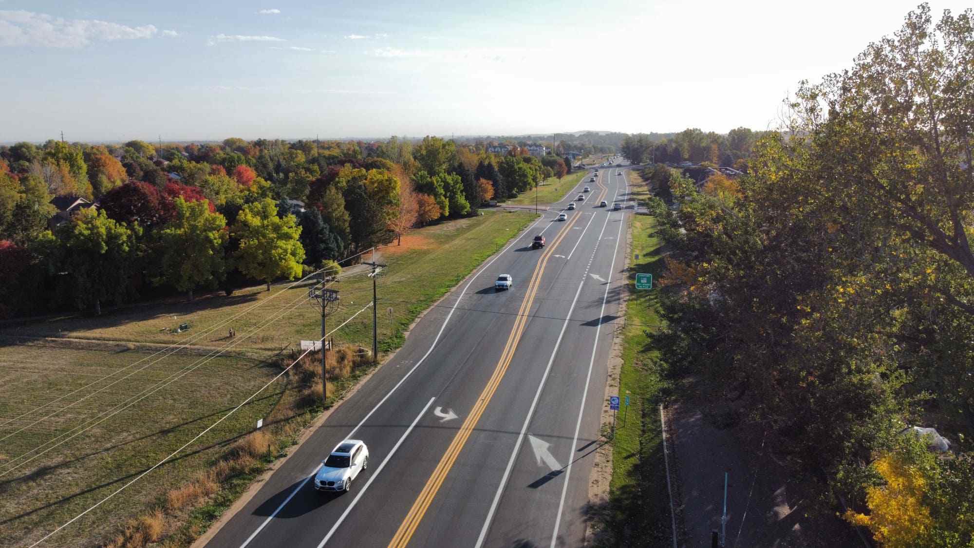 Street with moving vehicles and tree-lined sides in Denver, CO<br />
