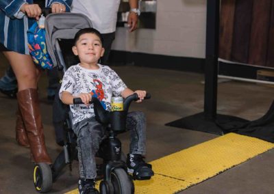 Child riding a tricycle indoors during the Brannan Company Picnic 2025 in Colorado