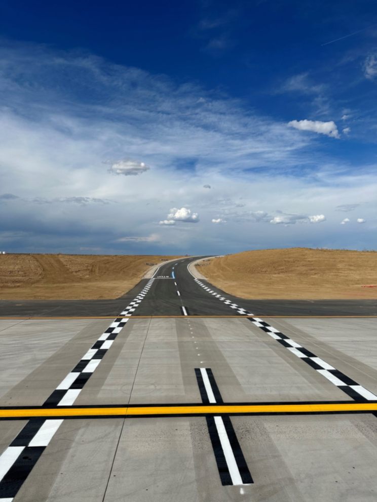 A Denver, CO runway displaying a distinct yellow line, guiding aircraft along the designated path for safe operations