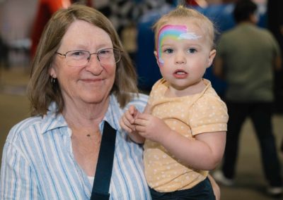 Grandma carrying granddaughter at Brannan Companies Picnic 2025 in Colorado