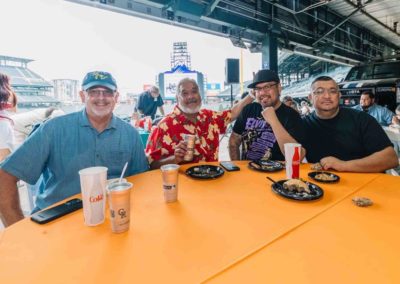 A group of people is posing while eating food during the Brannan Companies' annual picnic in Denver
