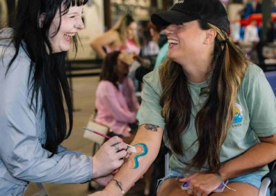 Guest getting a vibrant arm painting during the Brannan Company Picnic 2025 event in Colorado