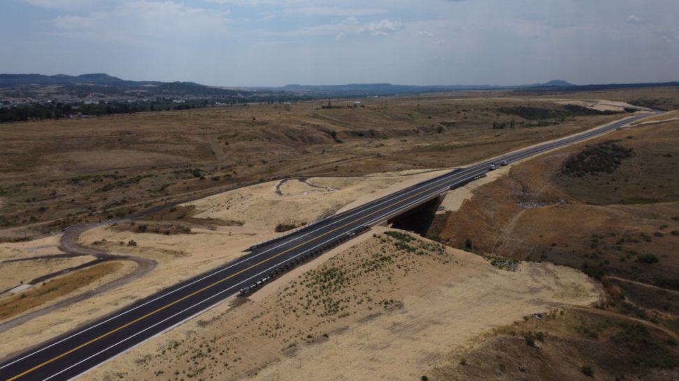 Aerial view of a highway cutting through a vast desert landscape near Denver, CO