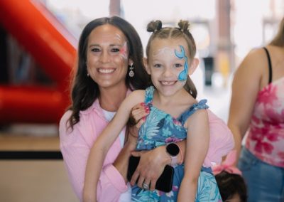 Parent and child are enjoying the face paint activity at the Brannan Companies picnic in Denver