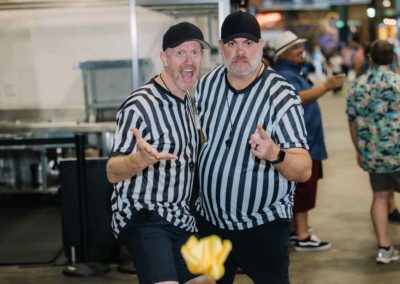 Two men wearing referee shirts pose for a picture at the Brannan Company Picnic 2025 in Denver, CO.