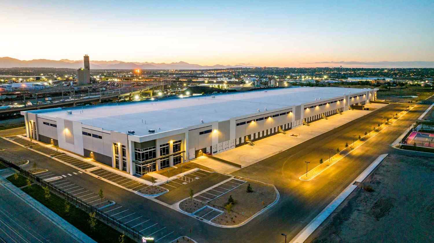 warehouse-asphalt-paving-1 The Brannan Companies project showing a modern warehouse building at dusk in Denver, CO.<br />