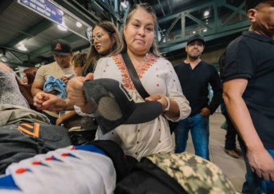 A woman is choosing a cap for herself at the Brannan Companies annual picnic in Denver, CO